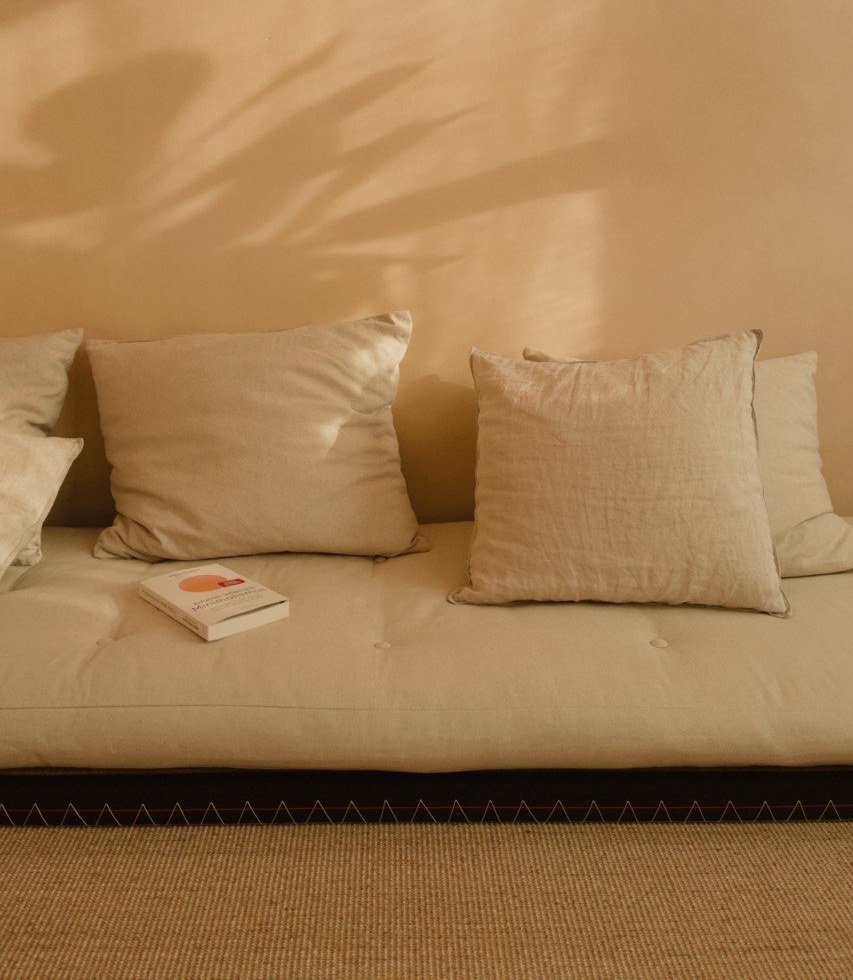 Das Buch &raquo;Erf&uuml;llter leben mit Minimalismus&laquo; liegt auf einem hellen Sofa